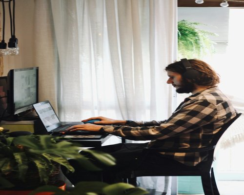 person typing on a laptop at home sitting at a moderate desk setup